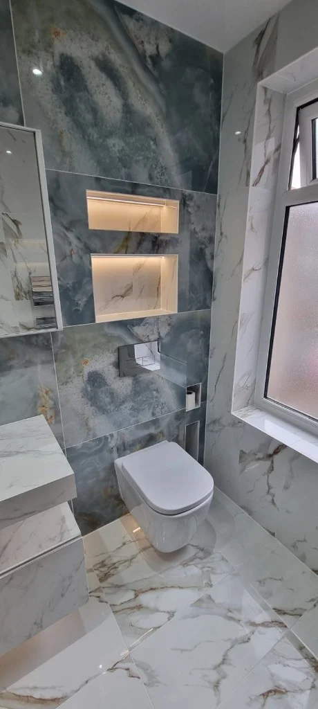 Floating toilet and marble tiling around window in Blyth