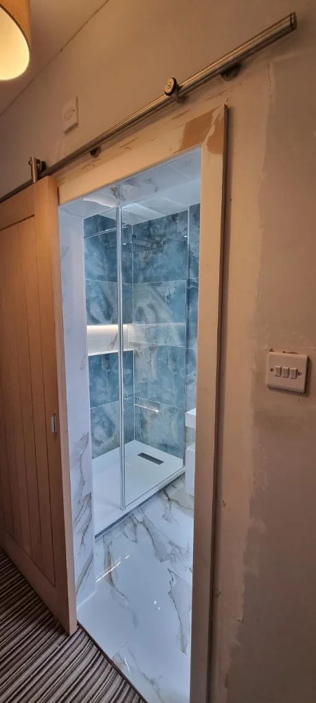 Wall-hung basin and floating toilet with tiled niches in Blyth