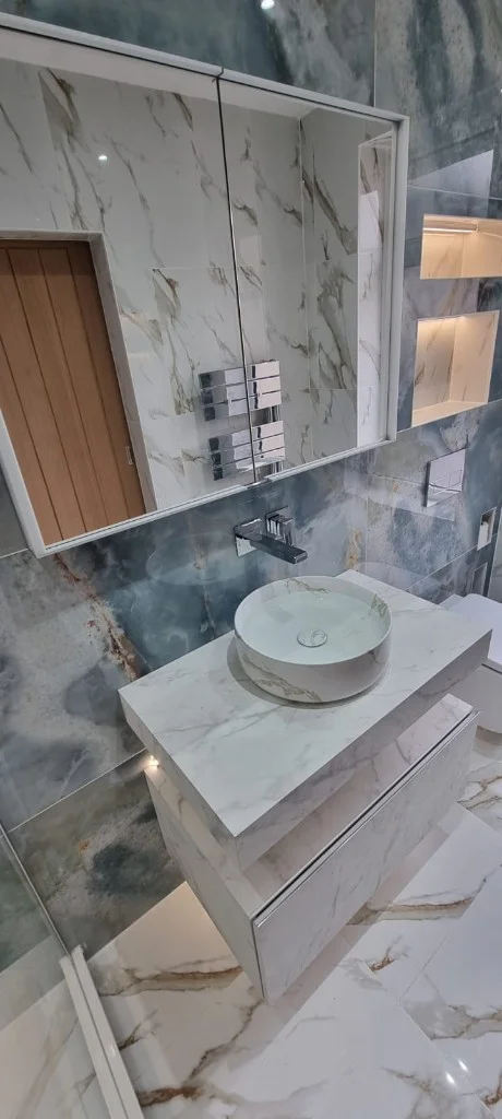 Shower area with rainfall head and marble-effect wall tiles in Blyth
