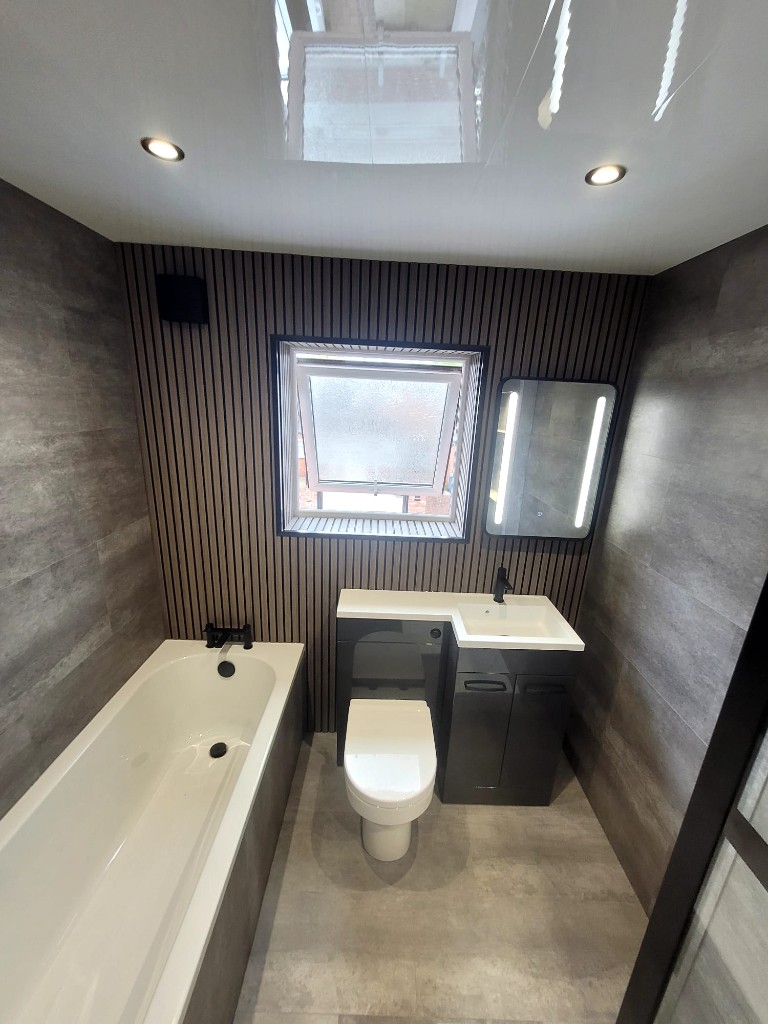 Built-in bath and vanity with wood slat wall in a Boldon bathroom