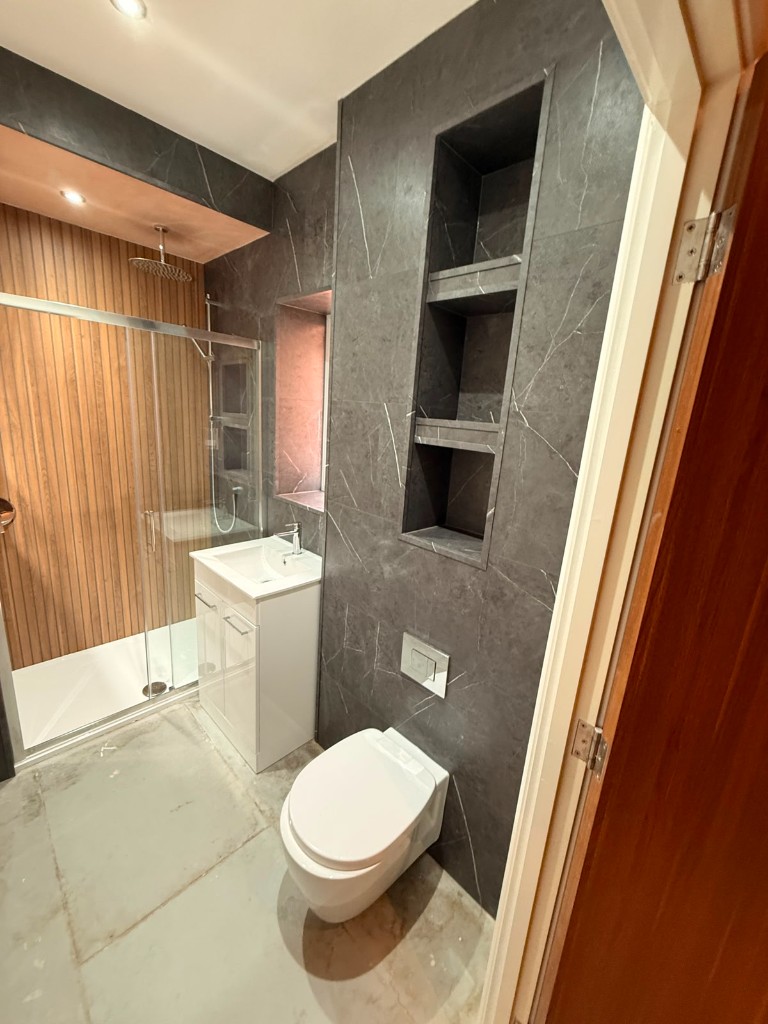 White gloss vanity and marble tile shower in a Durham bathroom