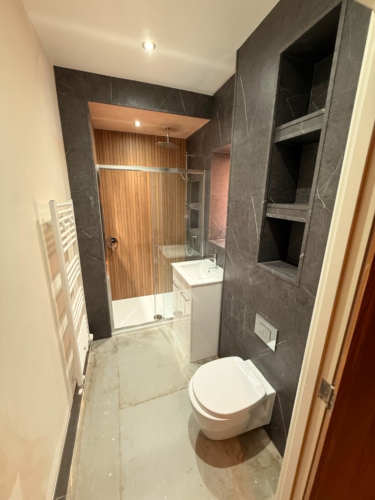 Durham bathroom with wood-slat shower wall and wall-hung toilet