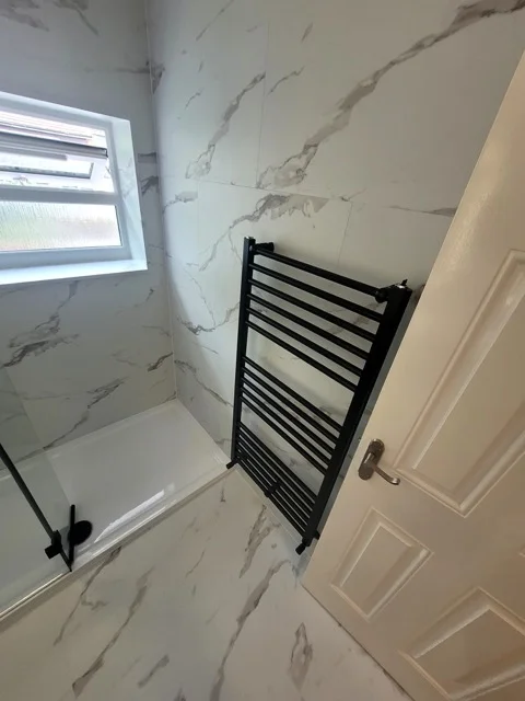 Black heated towel rail and SPC marble floor tiles in a Ramsbottom bathroom
