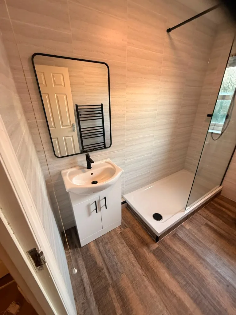 White vanity unit, black mixer tap and black-framed mirror in Tow Law bathroom