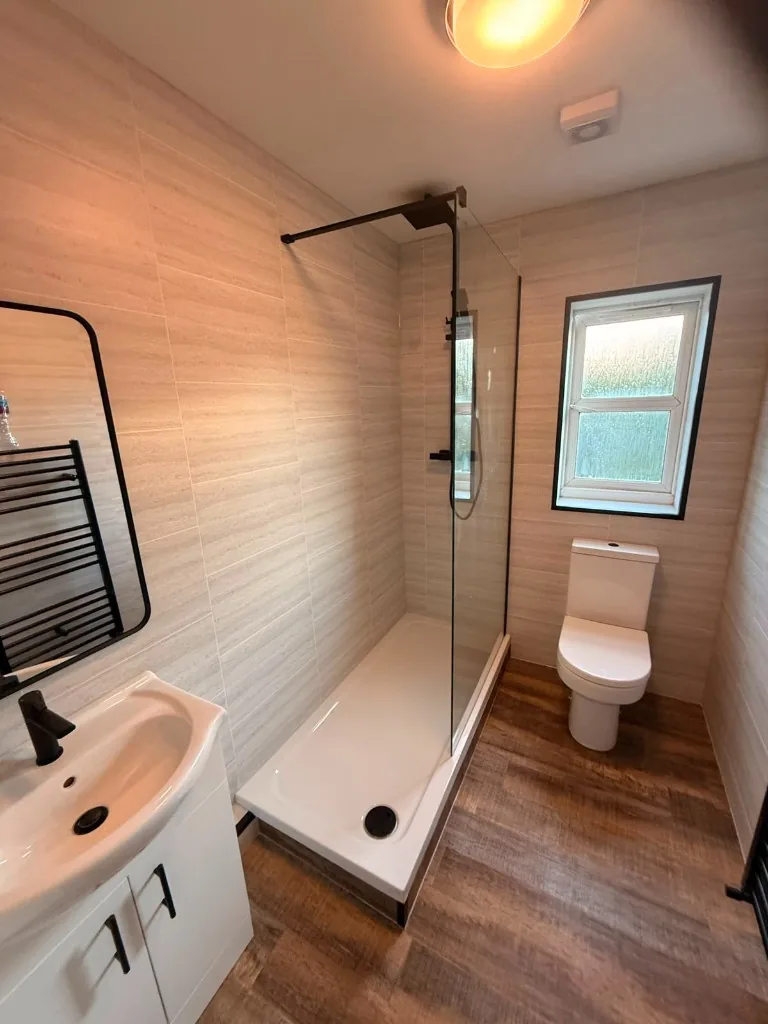 Tile-effect cladded bathroom with walk-in shower and black fittings in Tow Law