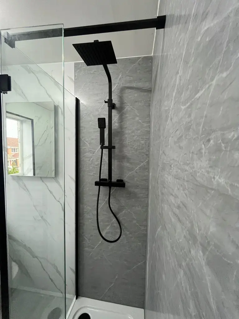 Matte black rainfall and handheld shower against grey marble-effect shower panels in Spennymoor