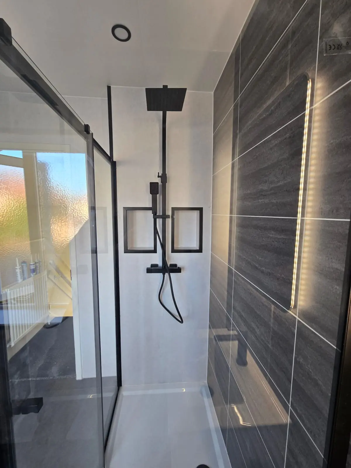 Black rainfall and handheld shower inside the cubicle beside the dark grey feature wall in Sunderland
