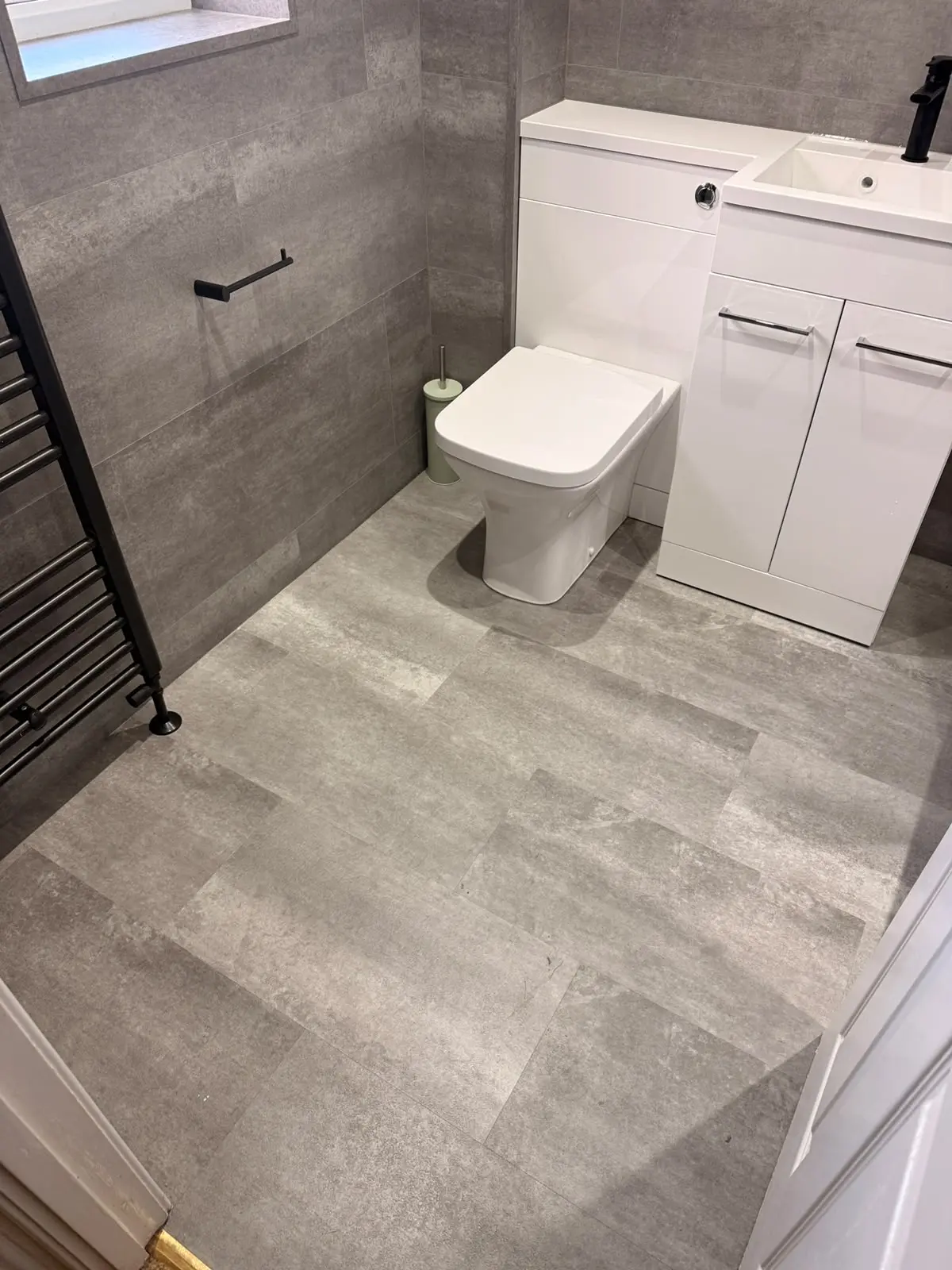 Doorway view of white combi toilet and vanity against medium-grey SPC walls in Chester-le-Street