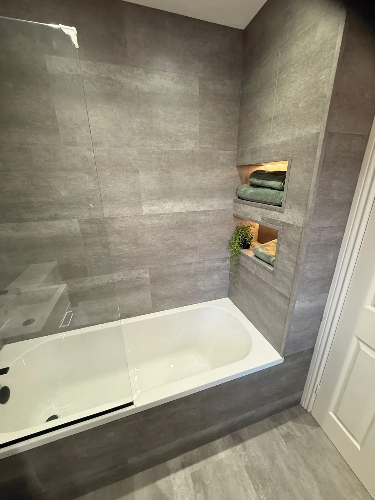 Bath with two LED-lit recessed niches at the end wall after renovation in Chester-le-Street
