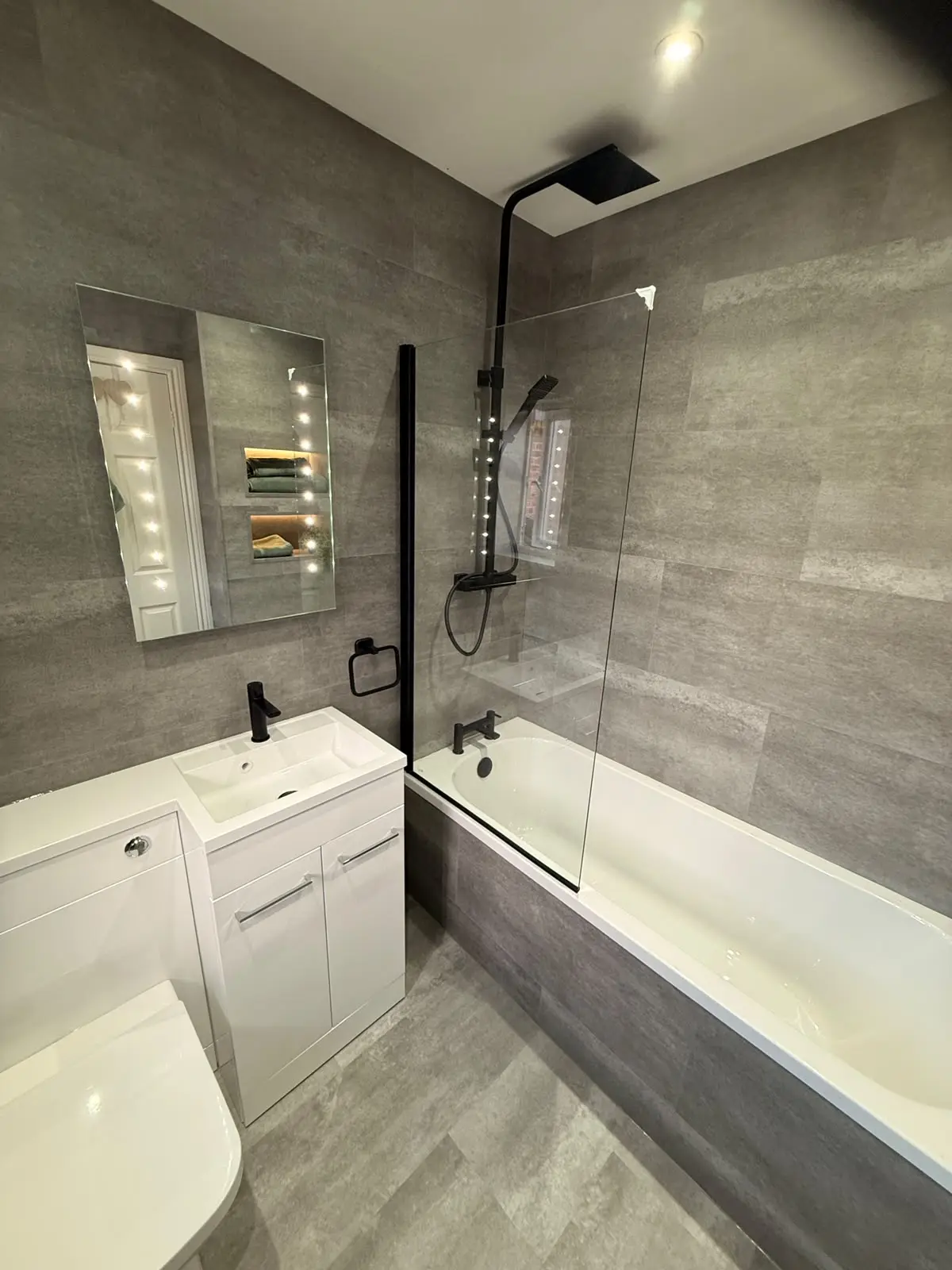 White combi vanity, black rainfall shower over bath and grey SPC walls after renovation in Chester-le-Street