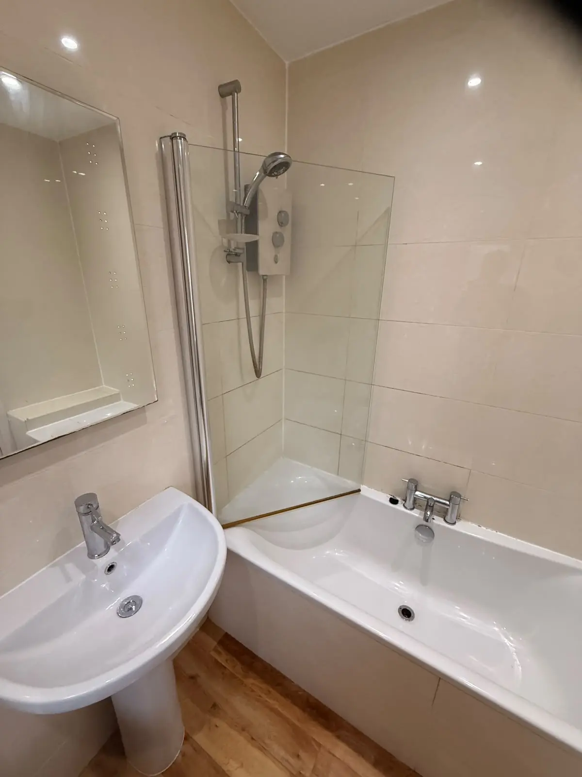 Pedestal basin, electric shower over bath and cream tiles before renovation in Chester-le-Street