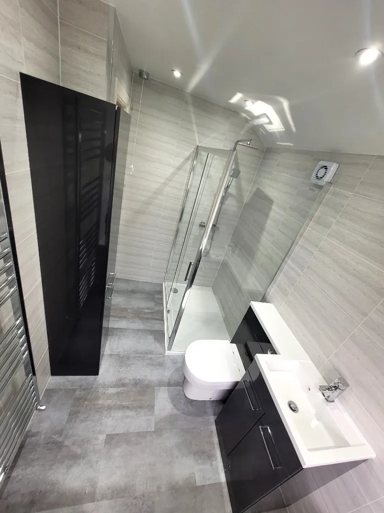 Cladded bathroom in Durham with shower quadrant, bath and anthracite vanity unit