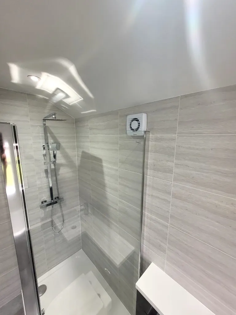 Shower enclosure with chrome fittings and grey horizontal cladding in Durham