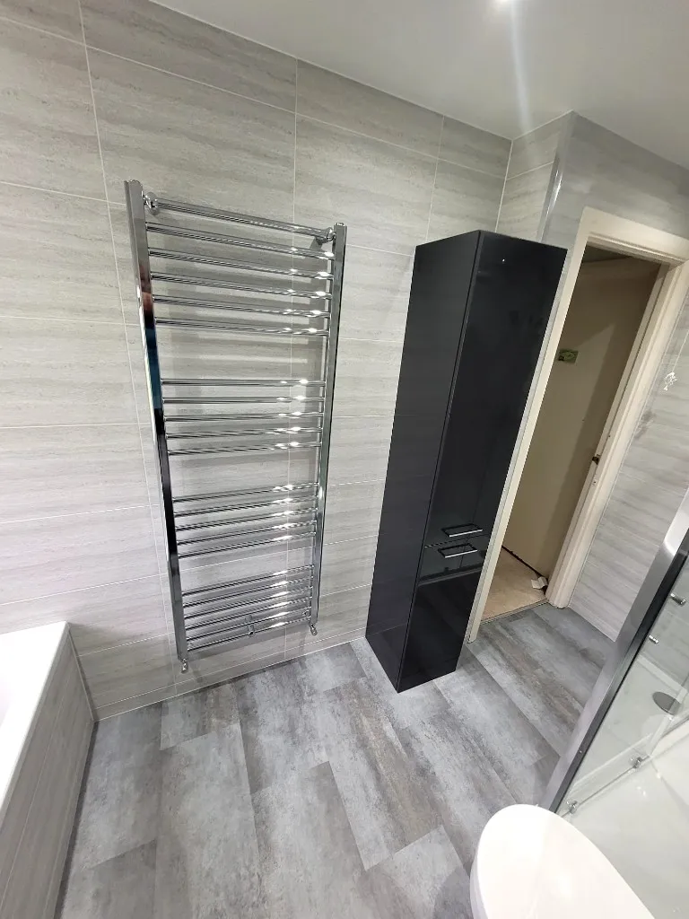 Tall anthracite storage unit and chrome heated towel rail in Durham bathroom