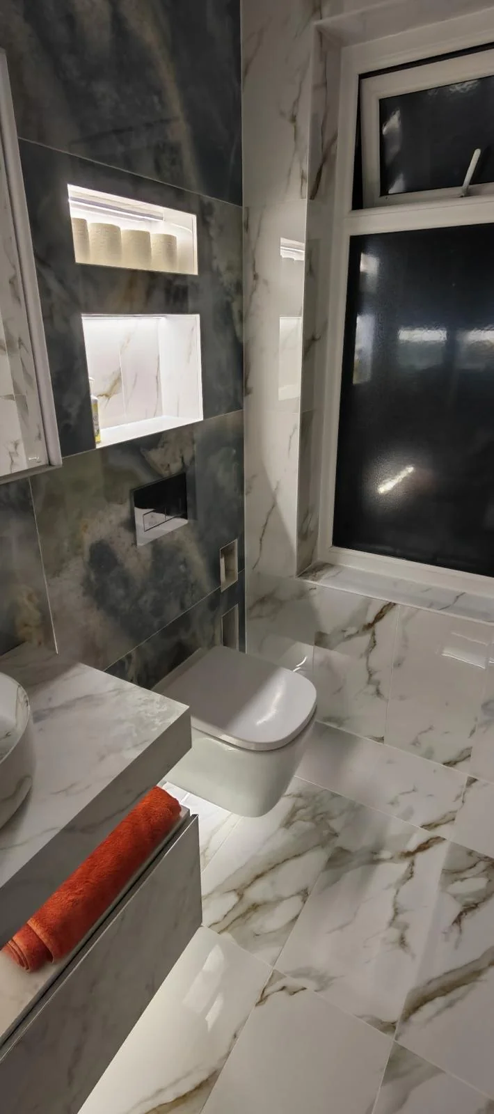 Floating toilet, LED niches and dark marble feature wall in Blyth bathroom