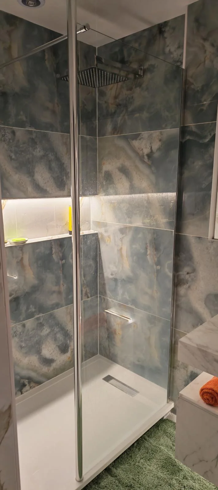 Fully tiled walk-in shower with LED strip recessed niche and rainfall head in Blyth