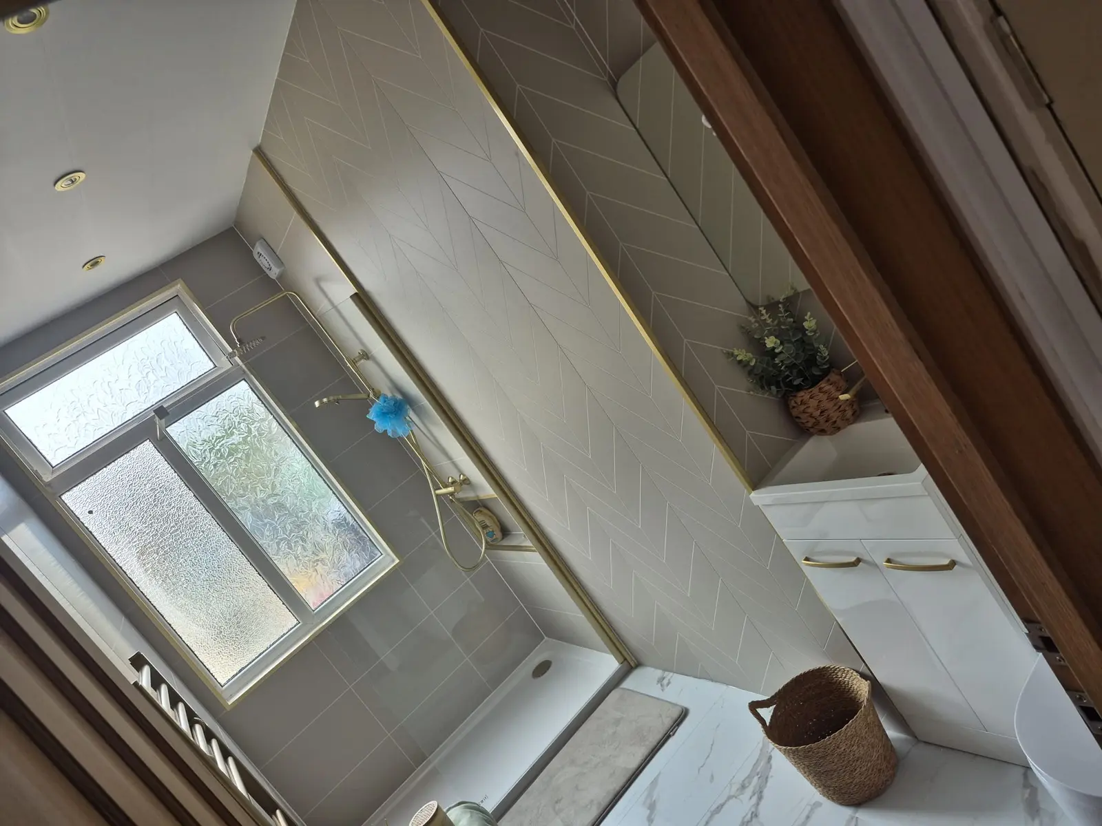 Wide view of the Darlington bathroom with walk-in shower, frosted window, herringbone feature wall and vanity