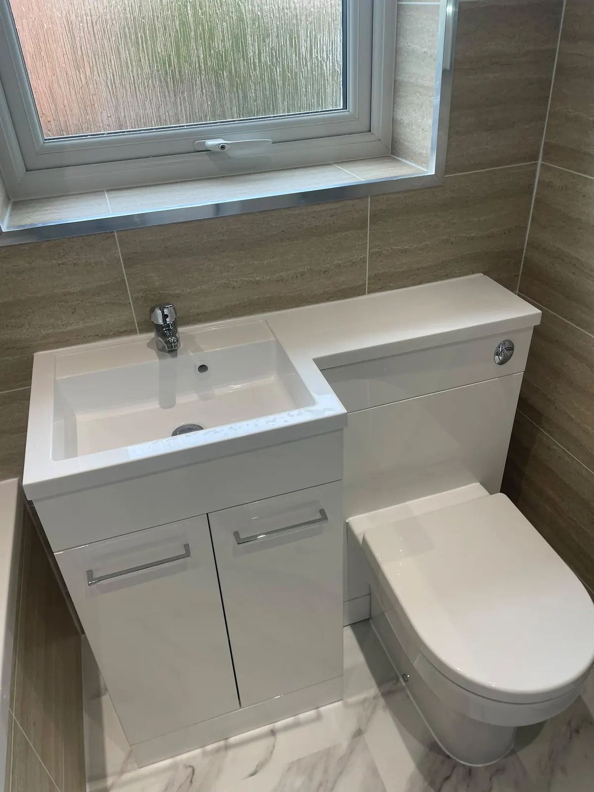 White combination sink, vanity and toilet unit with Murcia cladding and white marble flooring