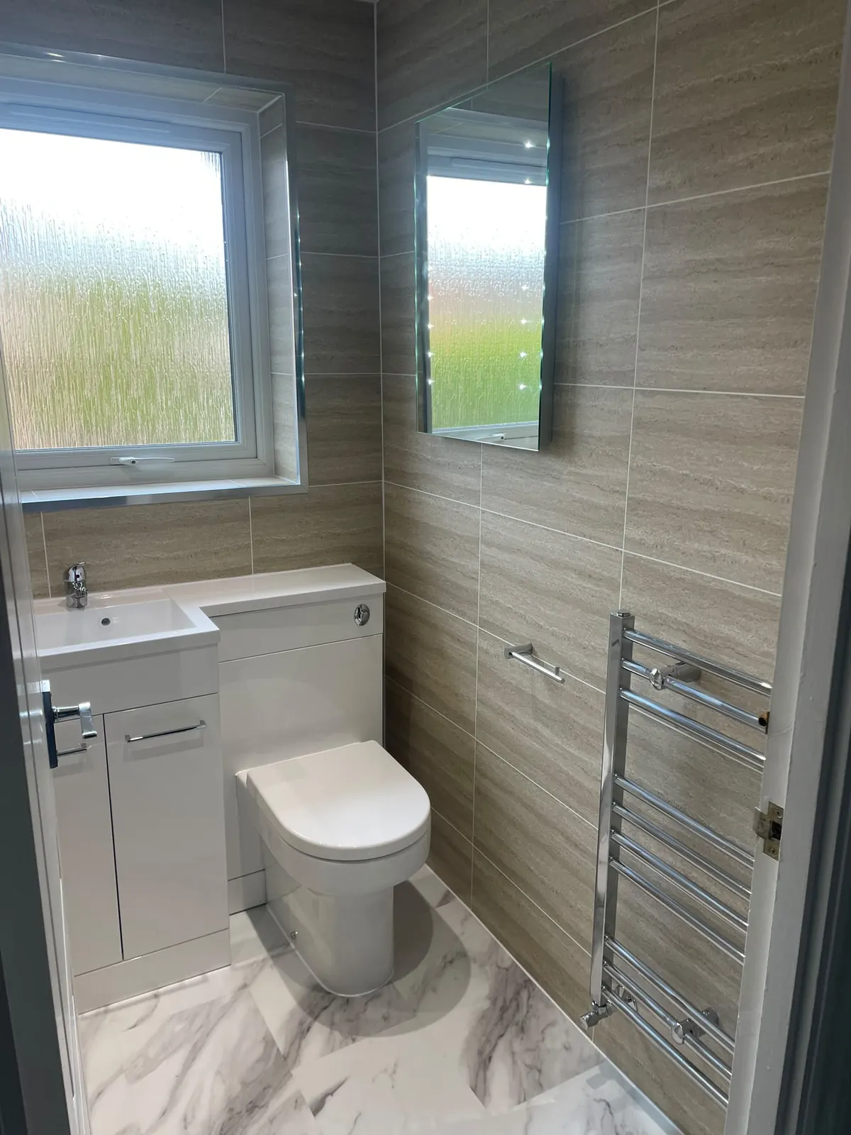 White combination sink, vanity and toilet unit with Murcia cladding and white marble flooring