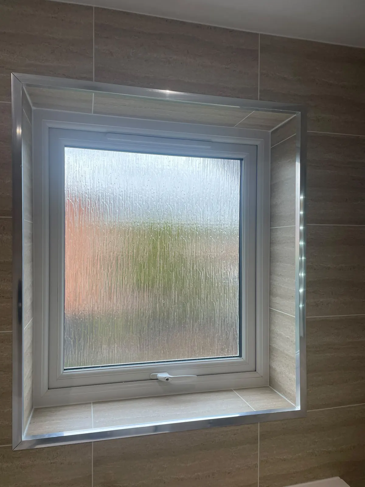 Frosted window set into Murcia cladding in the upstairs bathroom