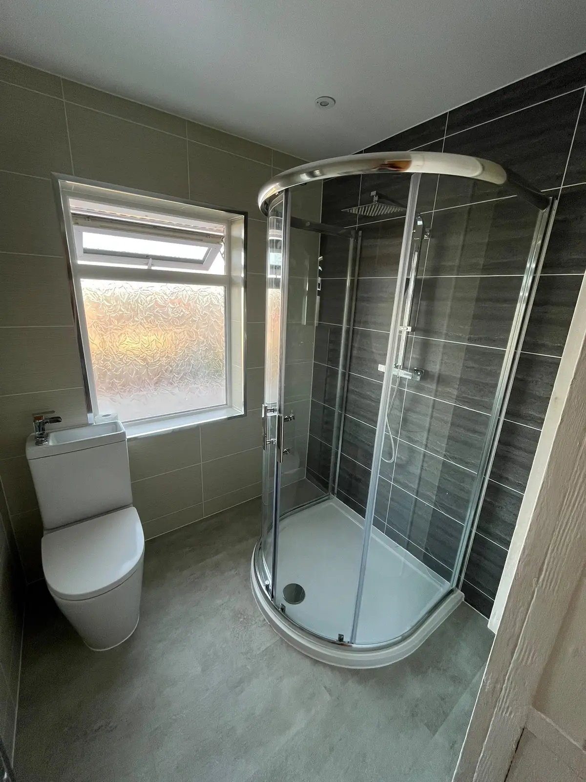 D-shaped shower cubicle beside toilet and frosted window in Quarrington Hill bathroom