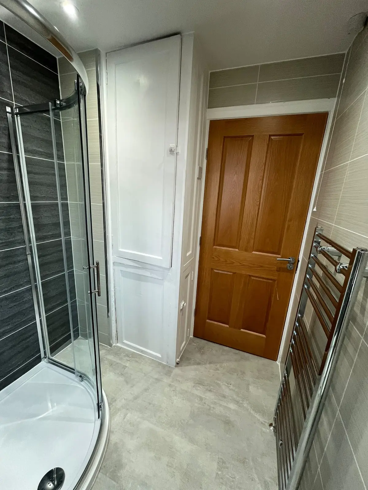 Shower, tall storage cupboard and door showing the compact Quarrington Hill bathroom layout