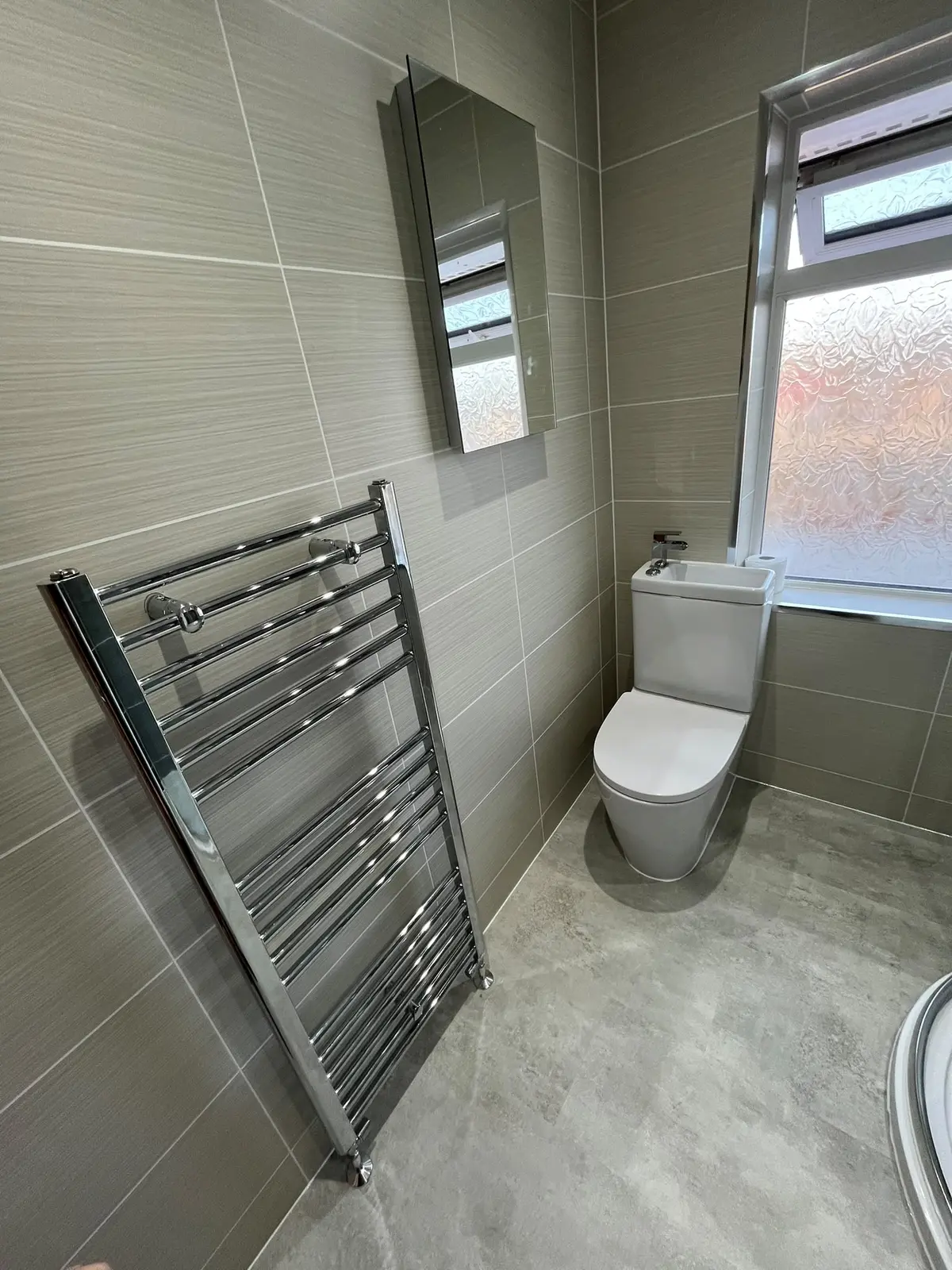 Space-saving toilet with cistern-top basin, LED mirror and chrome heated towel rail