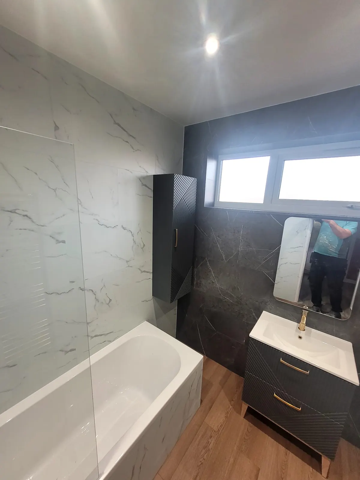 Floating vanity, matching wall unit and brass basin tap against a Venus Carrara feature wall in Durham