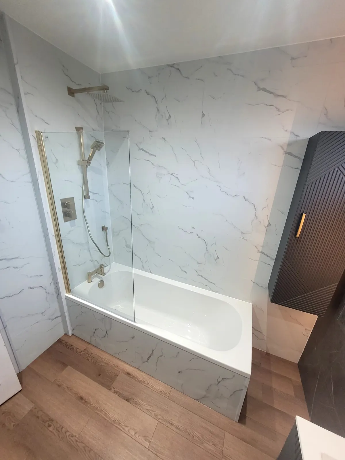 Bath with brushed brass shower screen and white Trevore SPC tiles in Durham