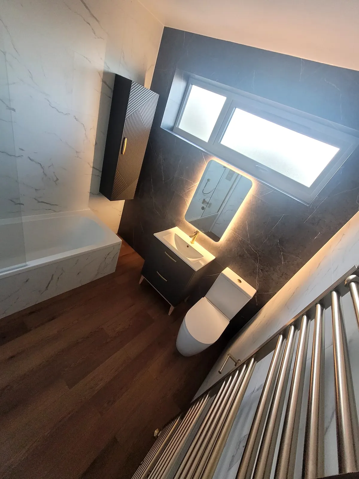 Floating vanity, toilet and brass towel rail with Venus Carrara feature wall in Durham