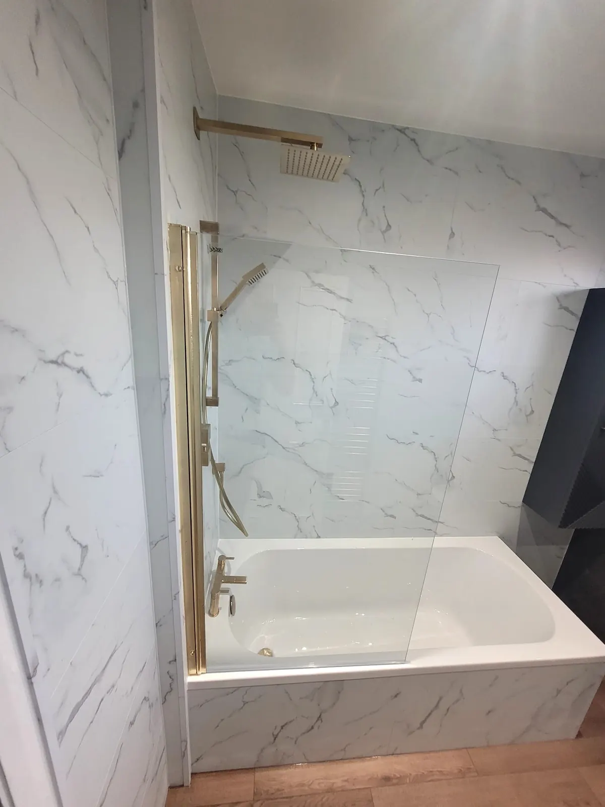 Glass bath screen with brushed brass uprights in a Durham bathroom