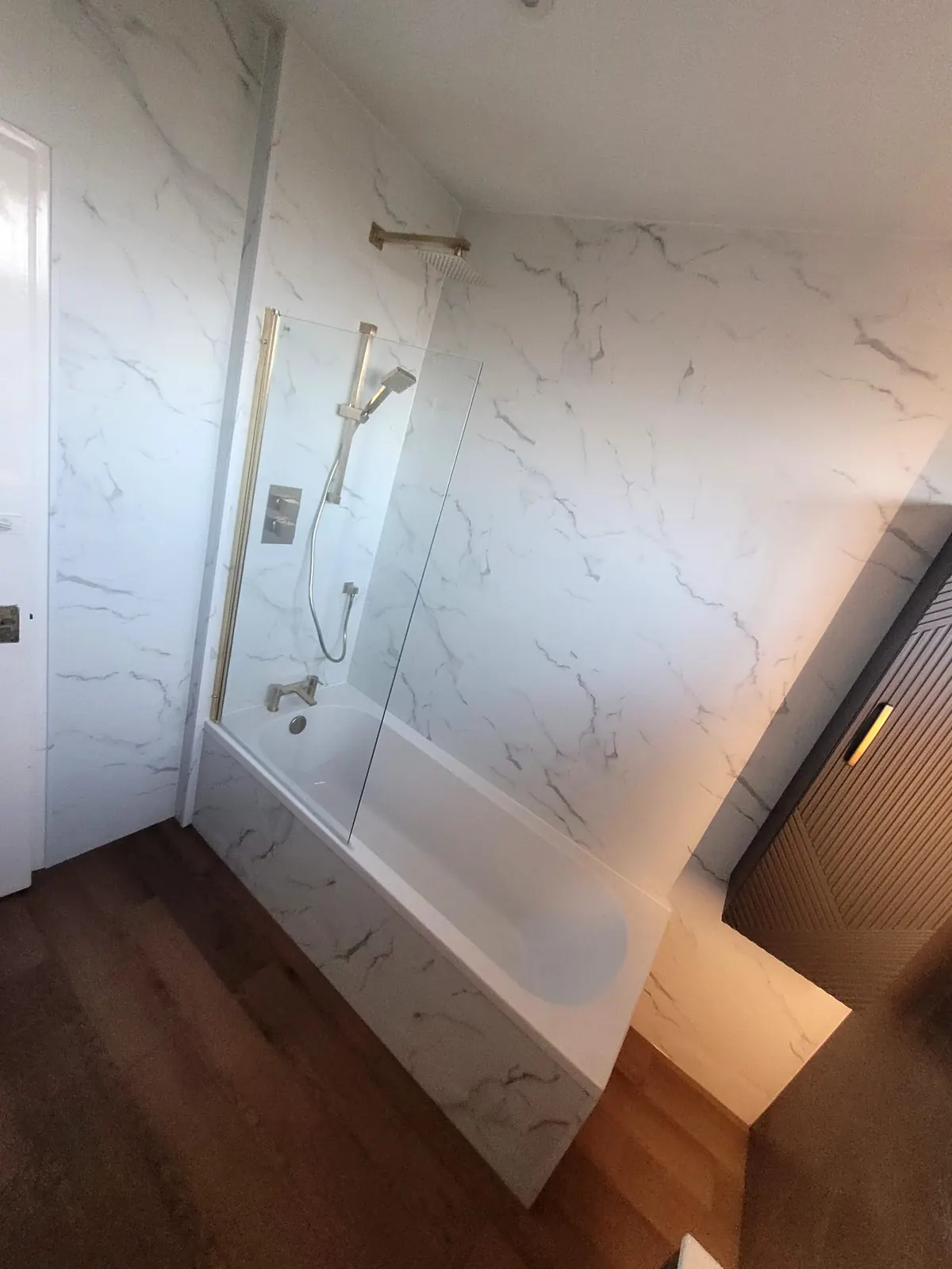 Shower over the bath with brass fittings and white Trevore SPC wall tiles in Durham