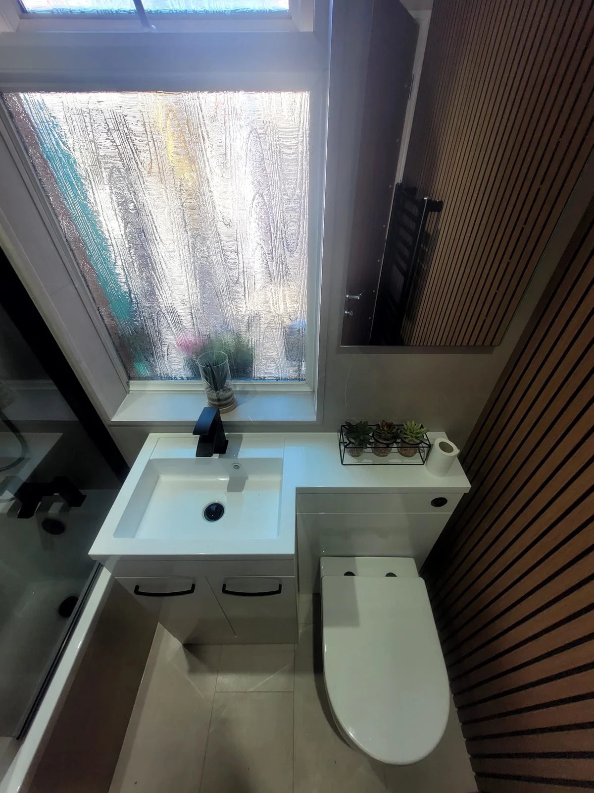 White vanity and back-to-wall toilet with wood-slat feature wall in Sunderland
