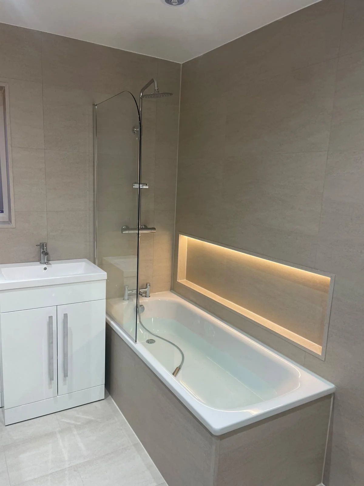 LED strip lighting feature along the bath recess in Billingham bathroom